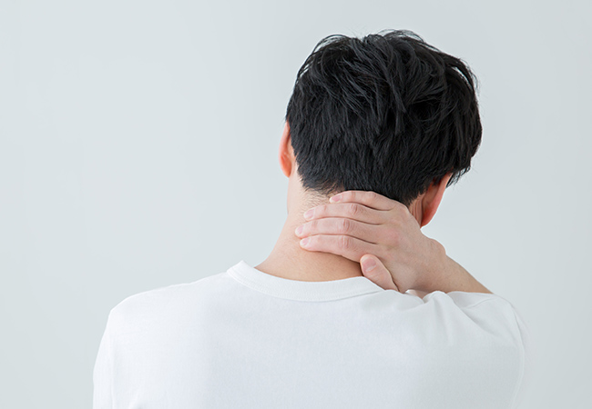 首を傾げて手を当てる男性