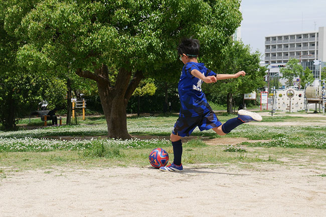 サッカーボールを蹴ろうとしている男の子